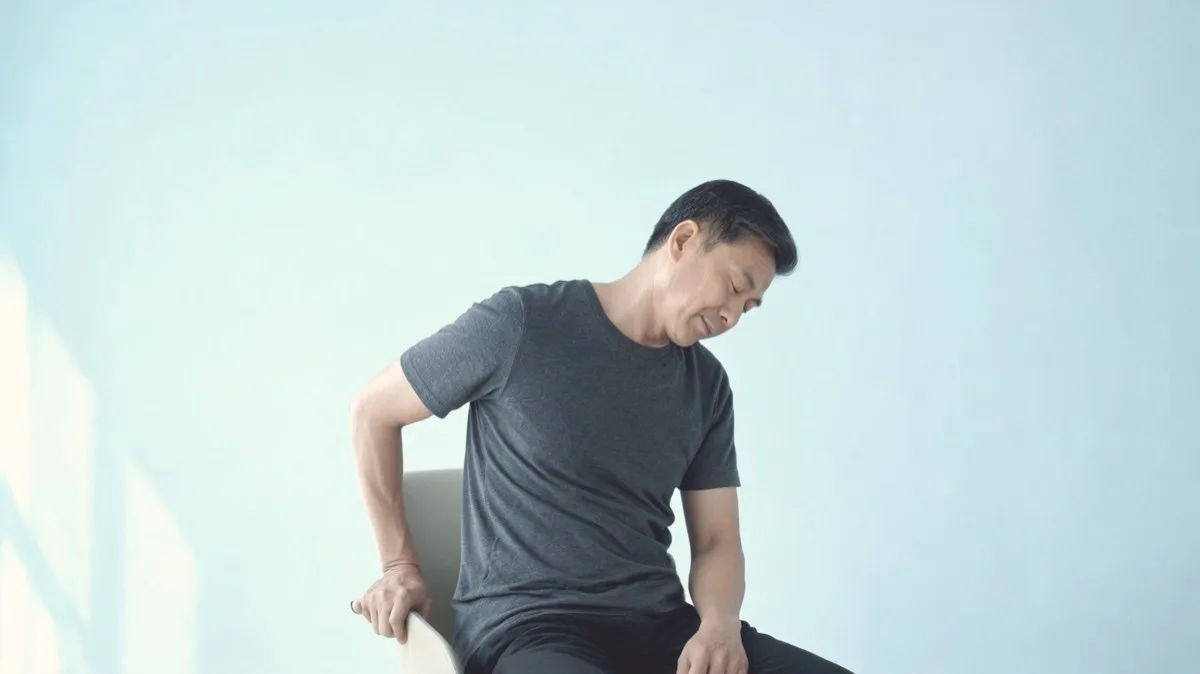 Upper trapezius stretch with hand anchored under the chair