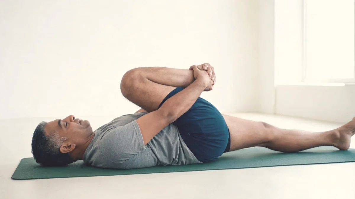 Knee to chest sciatica stretch lying on a mat
