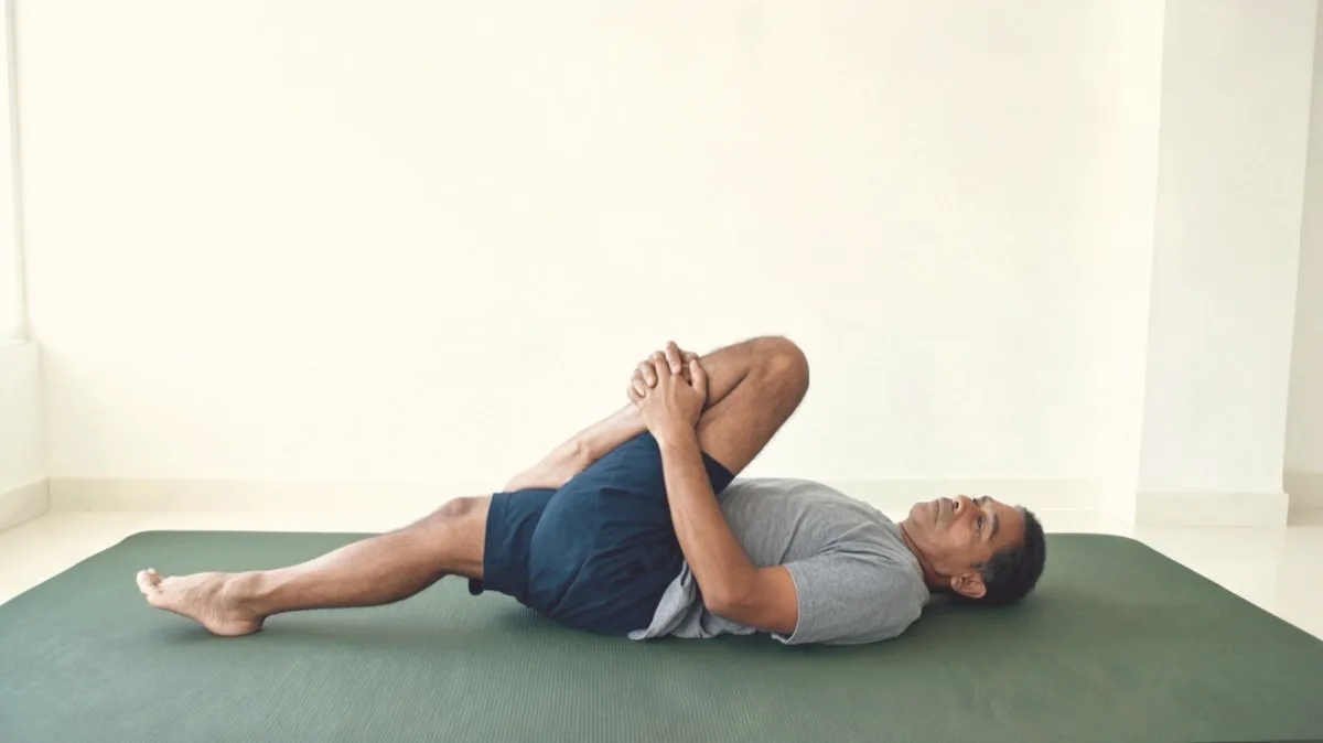 Pulling one knee gently toward the opposite shoulder