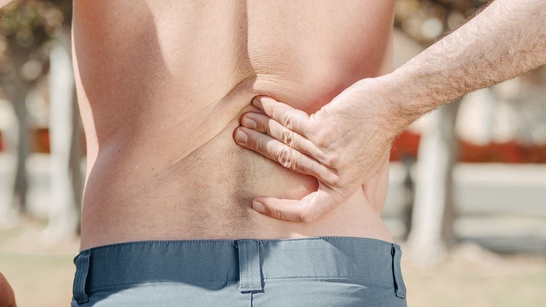 Person holding their lower back in pain