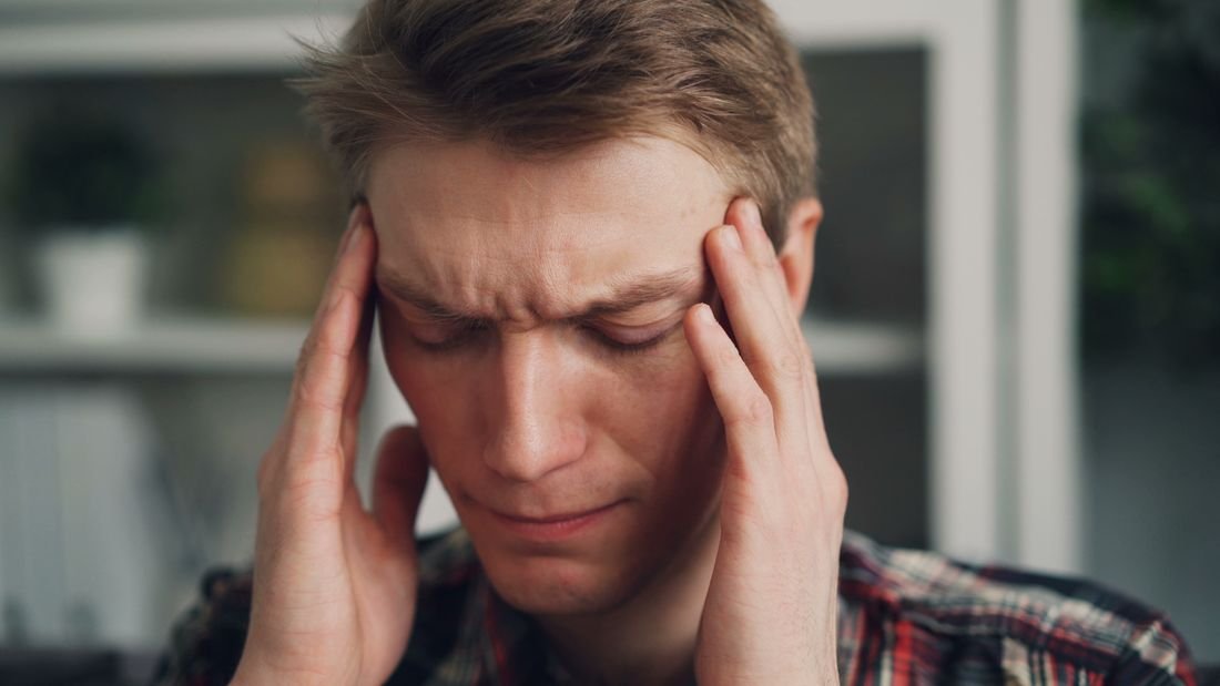 Man rubbing his temples with a tension headache